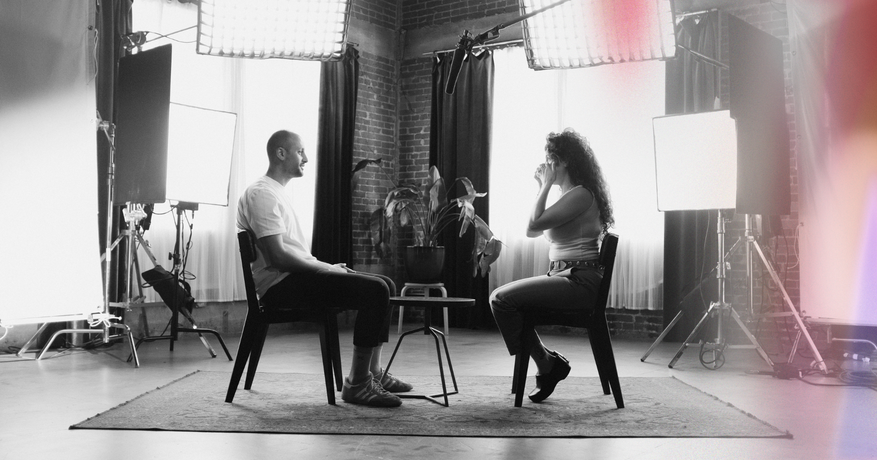 Picture of a man and a woman sitting across from each other in a lit set