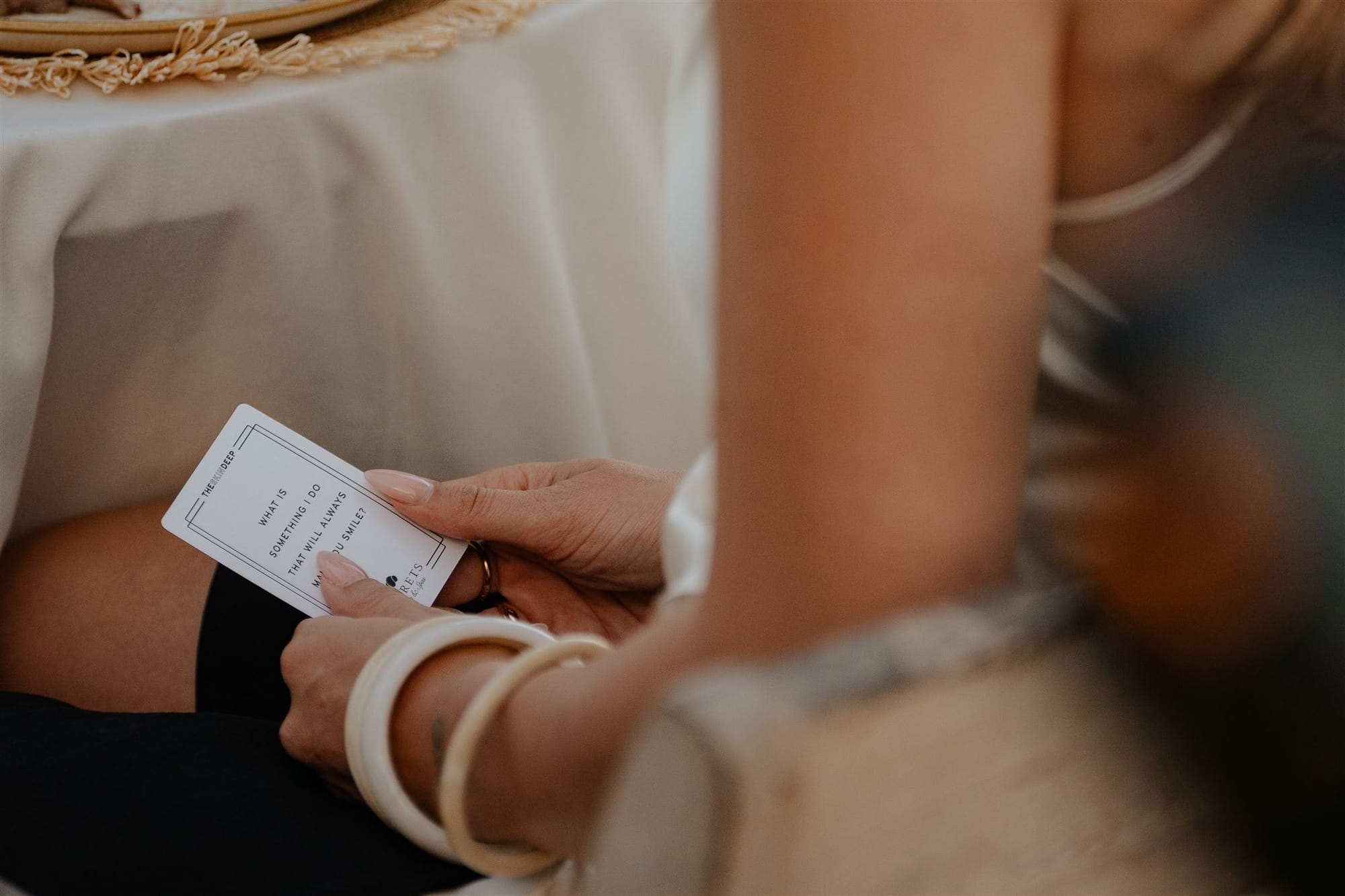 A woman holding one of {THE AND} cards