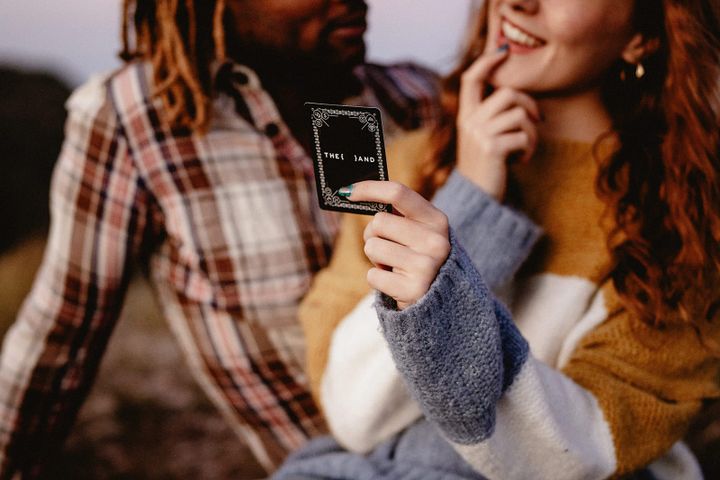 A couple playing {THE AND} Couples Edition while traveling