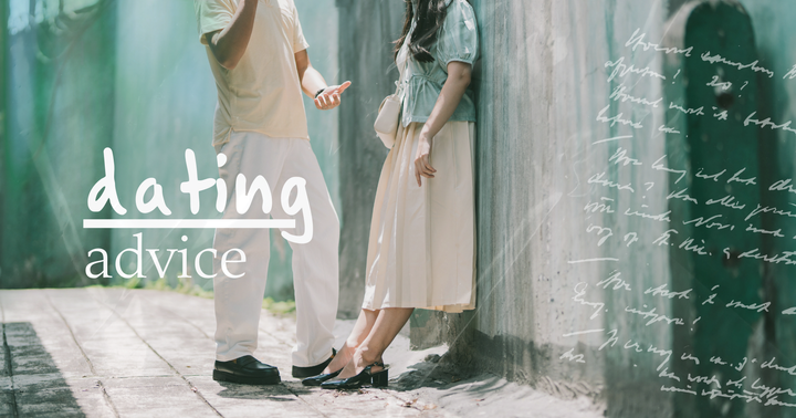 Picture of a man and a woman in a long skirt against a wall on the street having a conversation