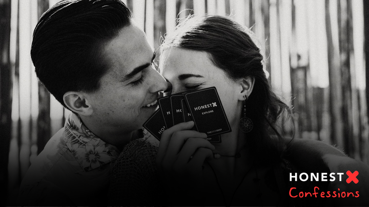 A couple holding honest x cards and smil