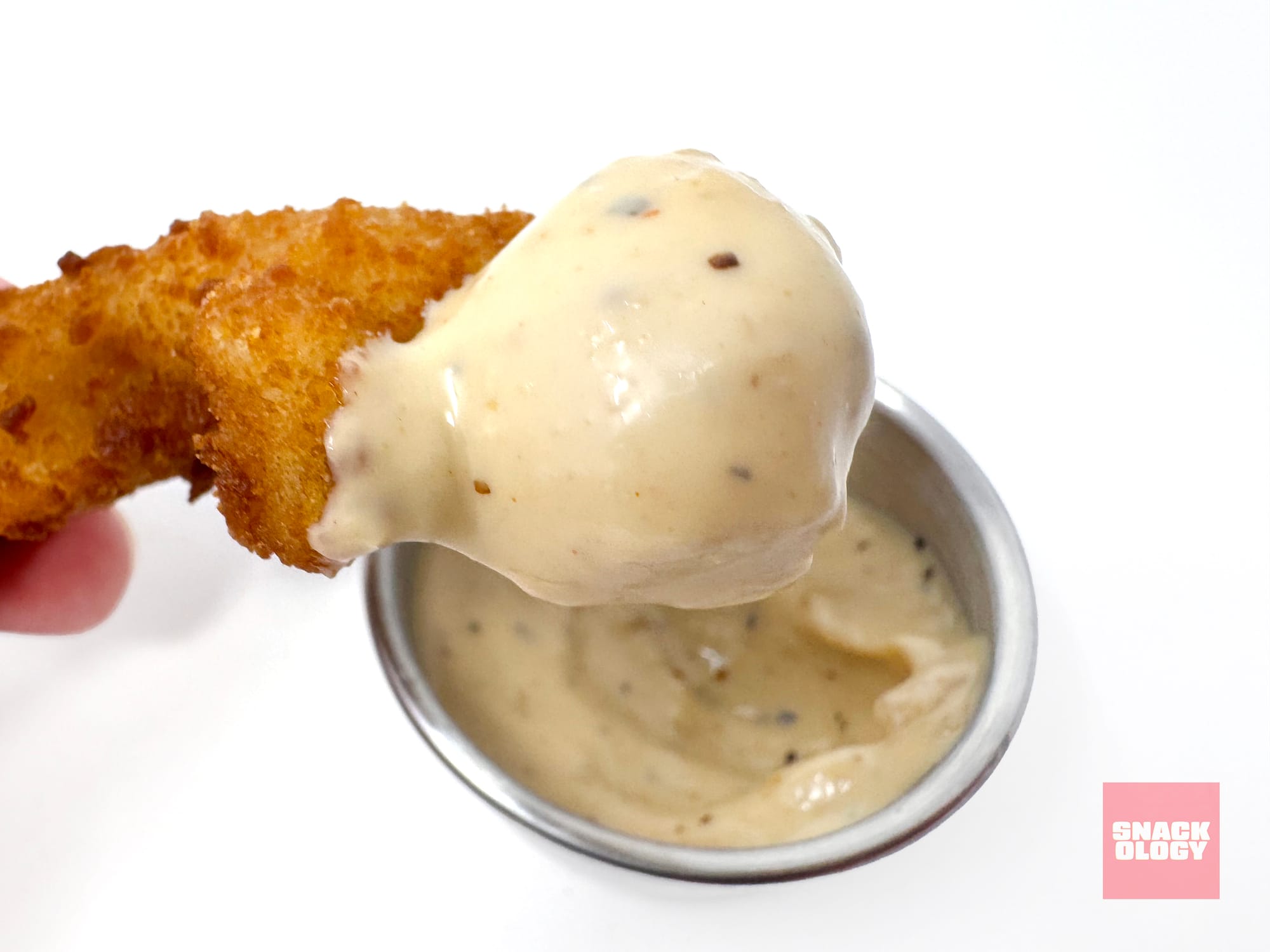 A dino nugget dipped in Heinz Steakhouse Garlic Mayonnaise-Style Dip. / Snackology