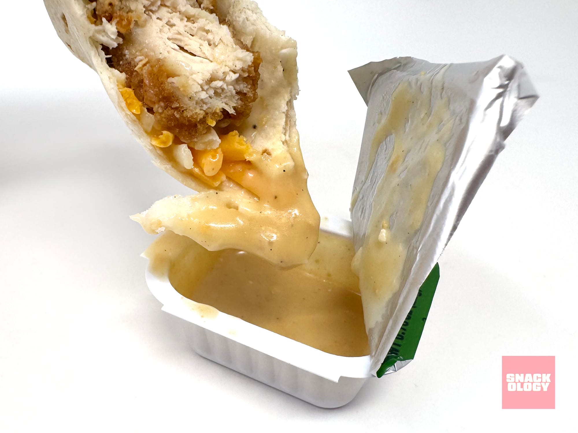 The Caesar Snack Wrap being dipped in more Caesar Sauce