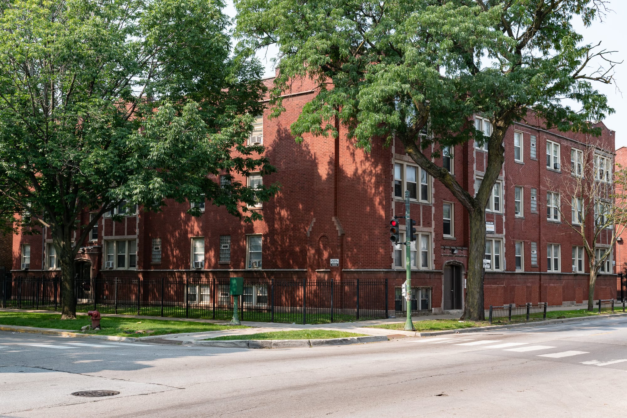 Chicago streetcorner with a red brick apartment building behind it