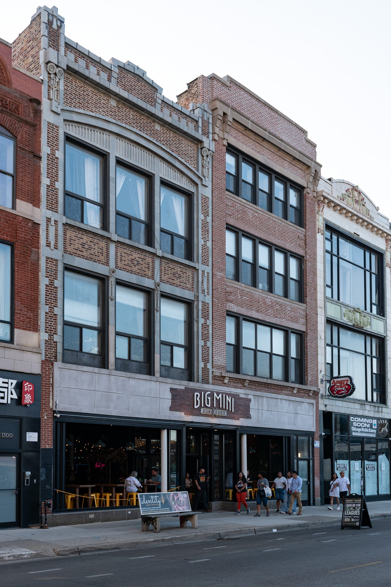 Big Mini Putt Club, a bench on the street, four story masonry buildings