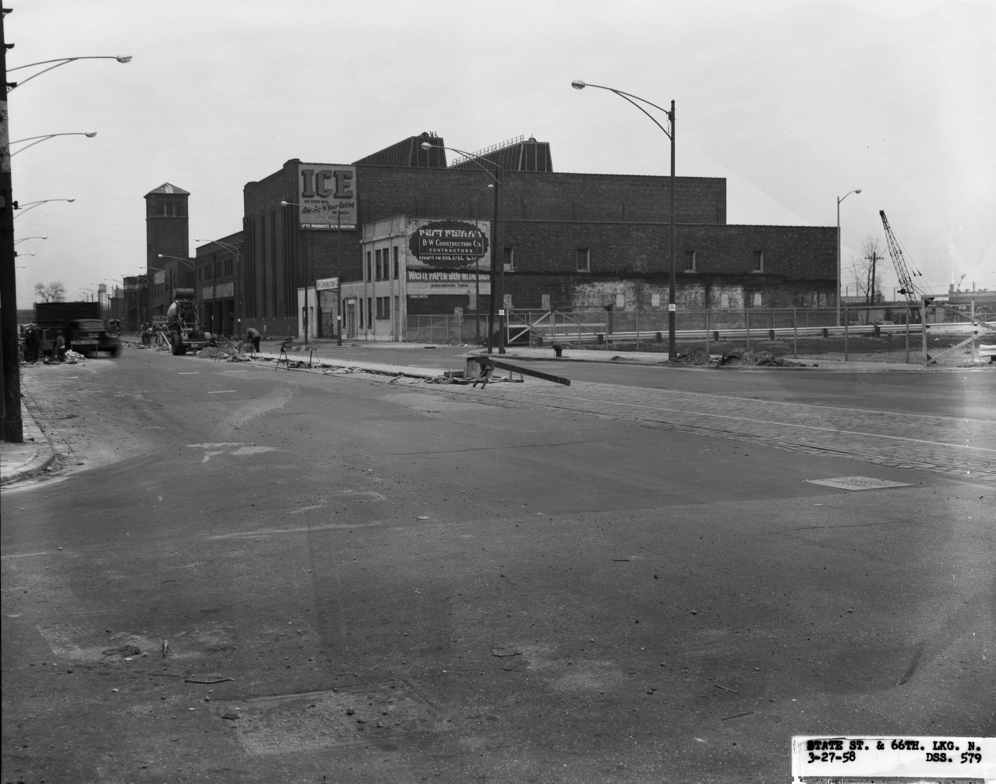 A two story building for a contractor, with an ice building in the background and a tower