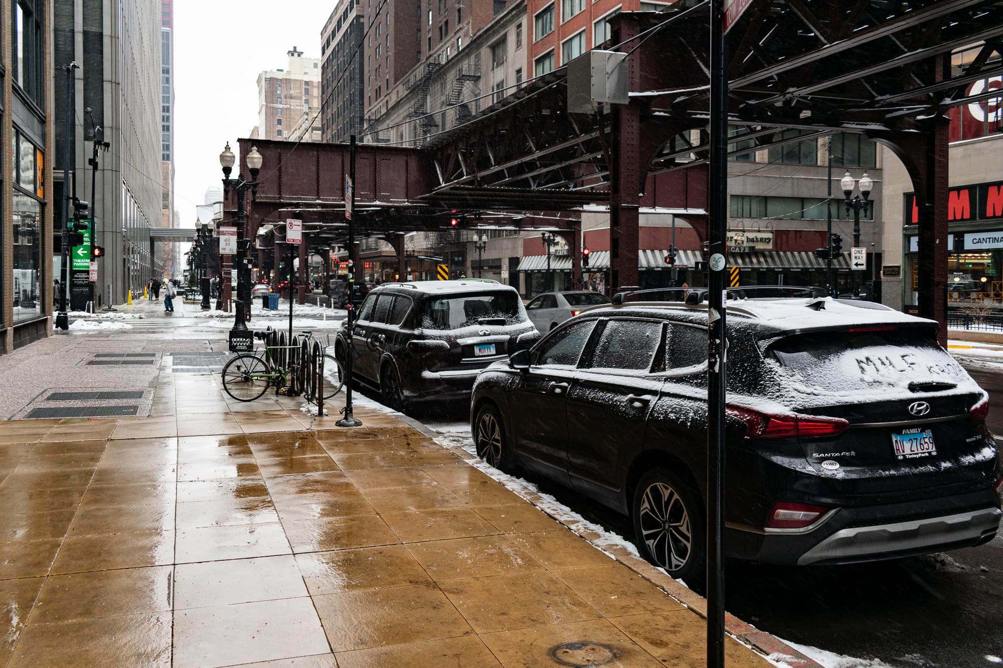 Bike racks, snow, parked cars, L structure, cleared sidewalk