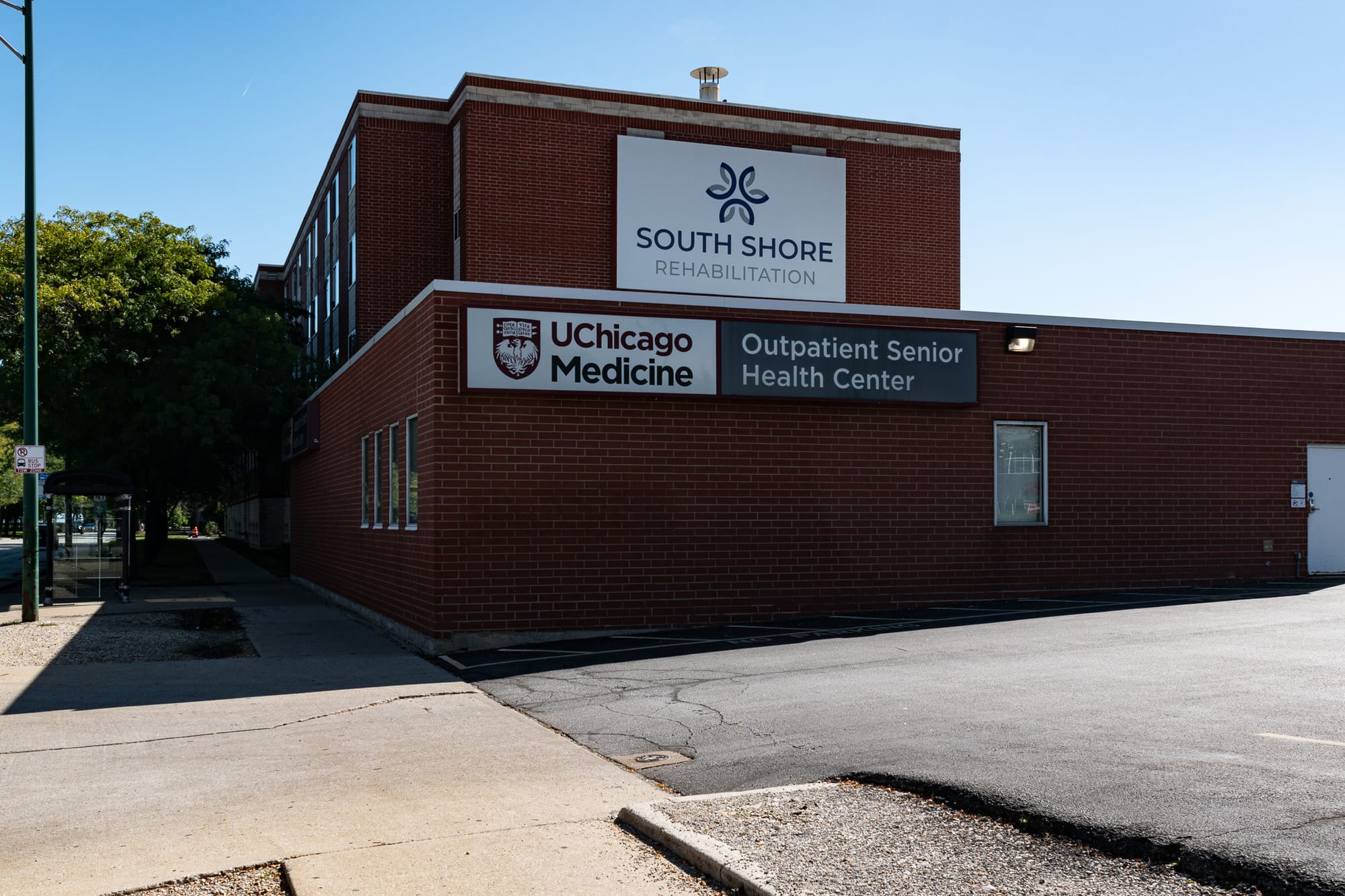 A brick building next to an asphalt parking lot, the sign says UChicago Medicine Outpatient Senior Health Center