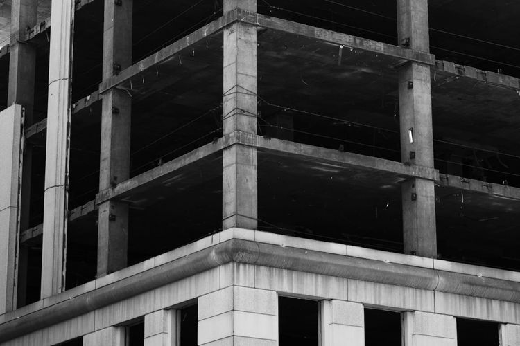 An unfinished concrete building with multiple exposed floors and raw structural beams, representing the layered sequencing that determines whether a data team can build on solid foundations.