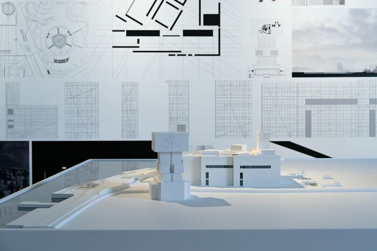 An architectural model alongside blueprint drawings pinned to a wall, representing the formal document that turns an implicit data agreement into an explicit one.