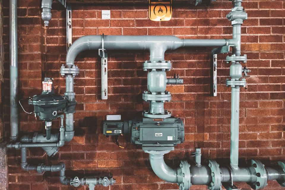 A close-up of black and grey metal pipes in an abstract industrial arrangement, representing the deliberate infrastructure choice that determines how data moves through the system.