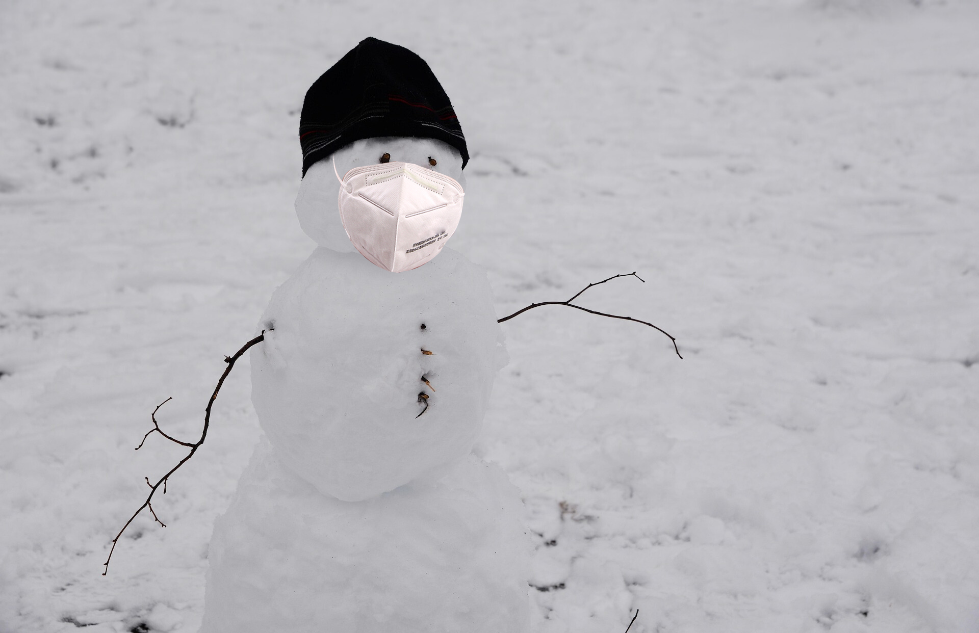Snowman wearing a white KN95
