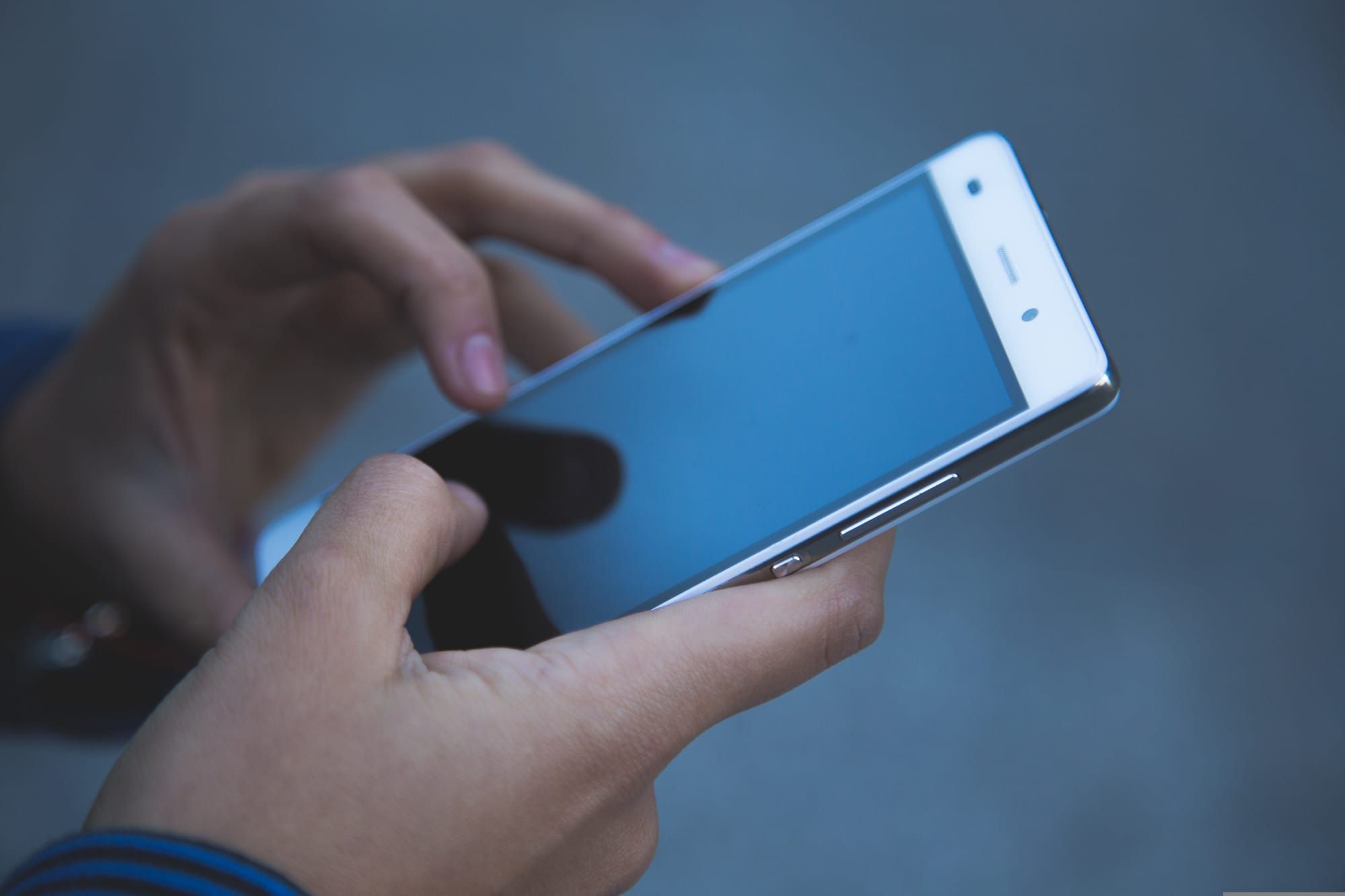 Hands of a young woman of color holding a mobile phone