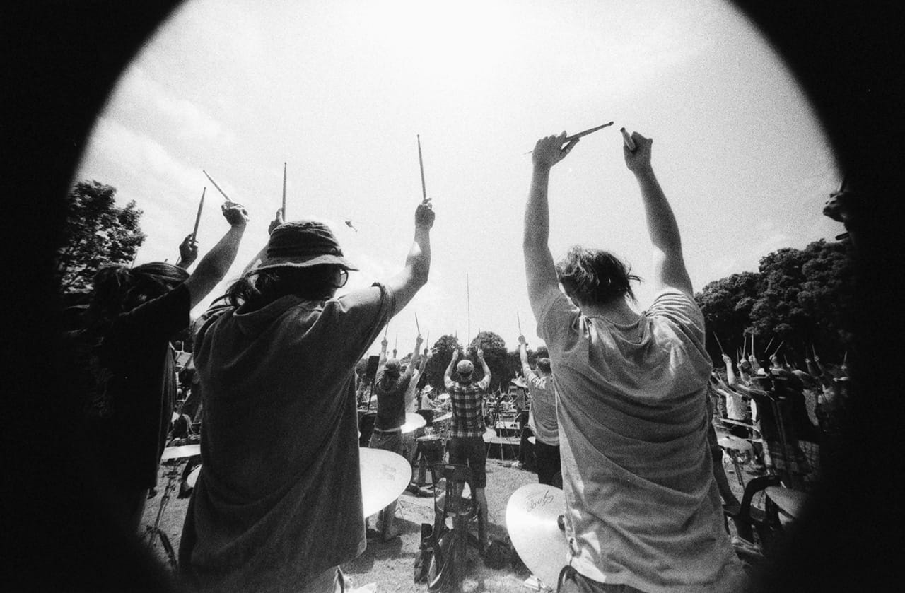 The players await the official Aerial Photography from an approaching helicopter - Boredoms - Boadrum111 - Byron Bay November 2011