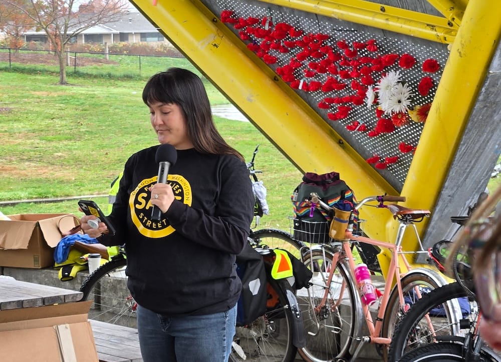 Photo of Portland Council Vice President Tiffany Koyama Lane wearing a Families for safe Streets sweatshirt and speaking at the event.