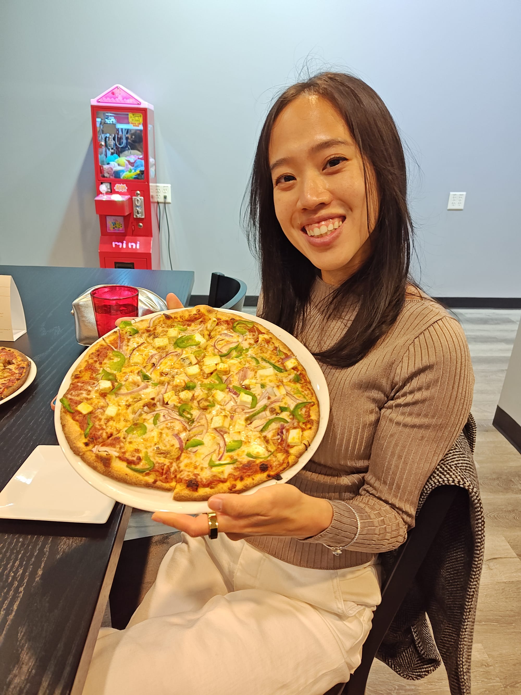 woman smiling and holding an indian pizza