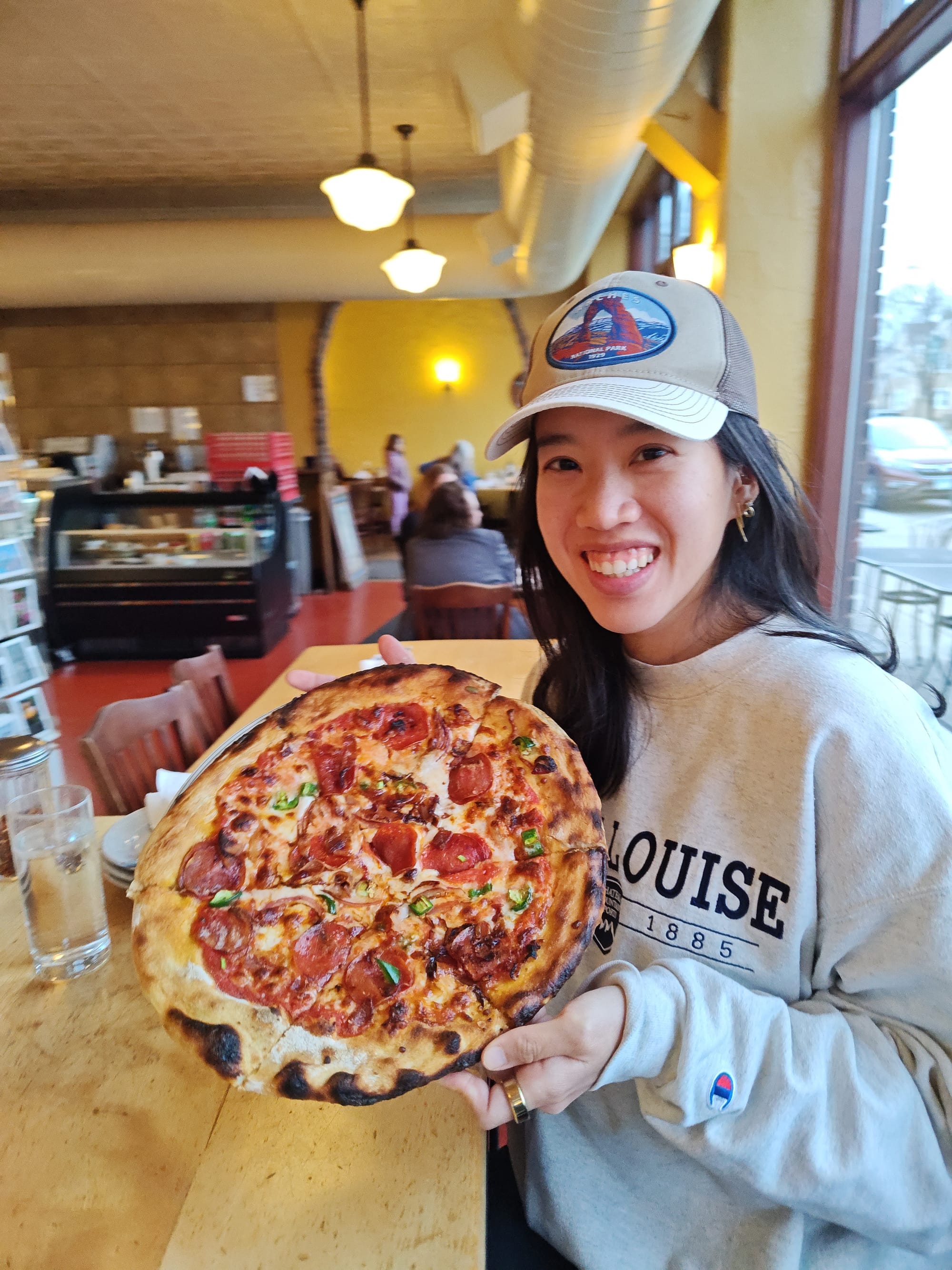 woman holding a meat pizza