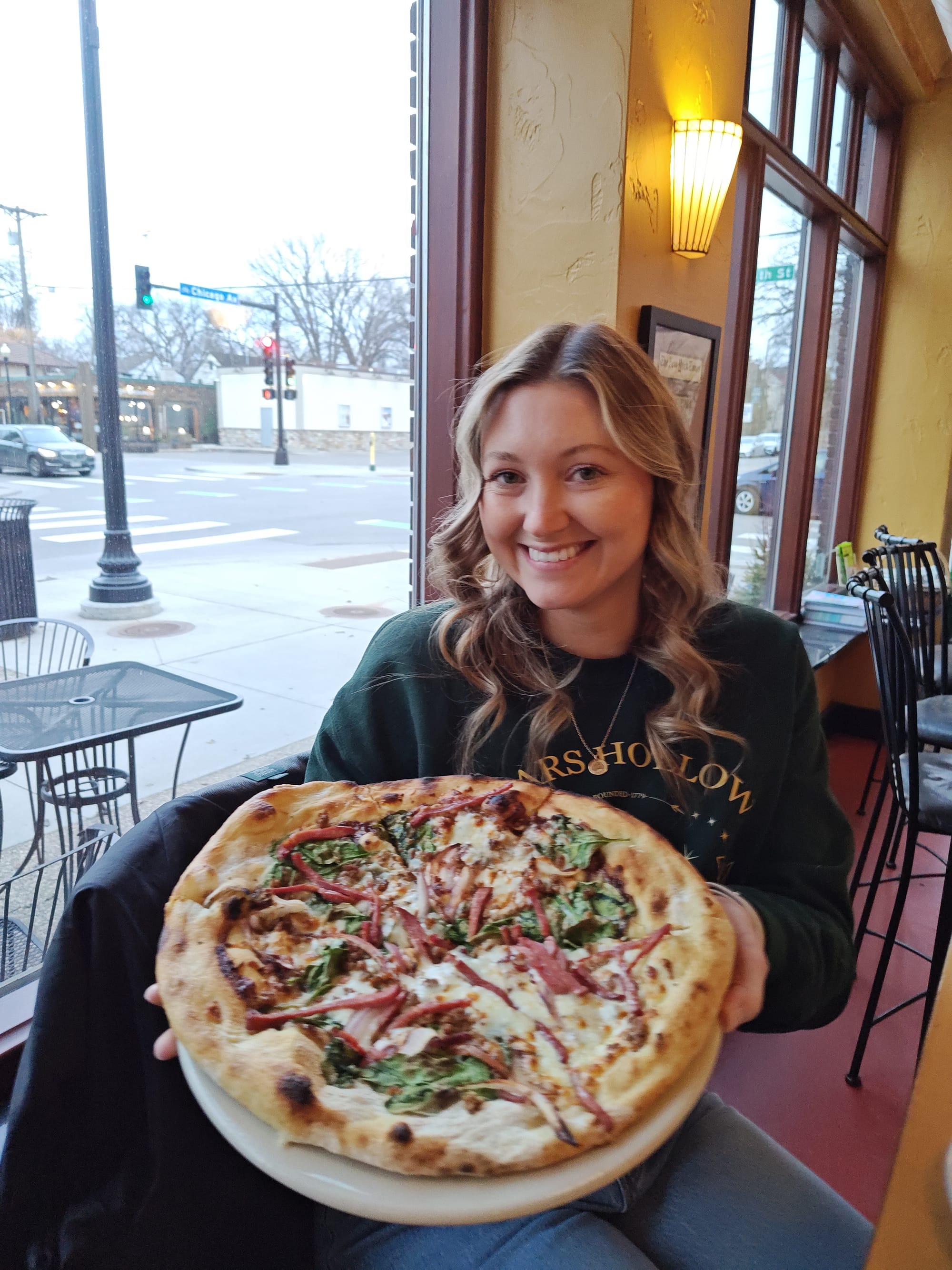 woman holding a sausage pizza