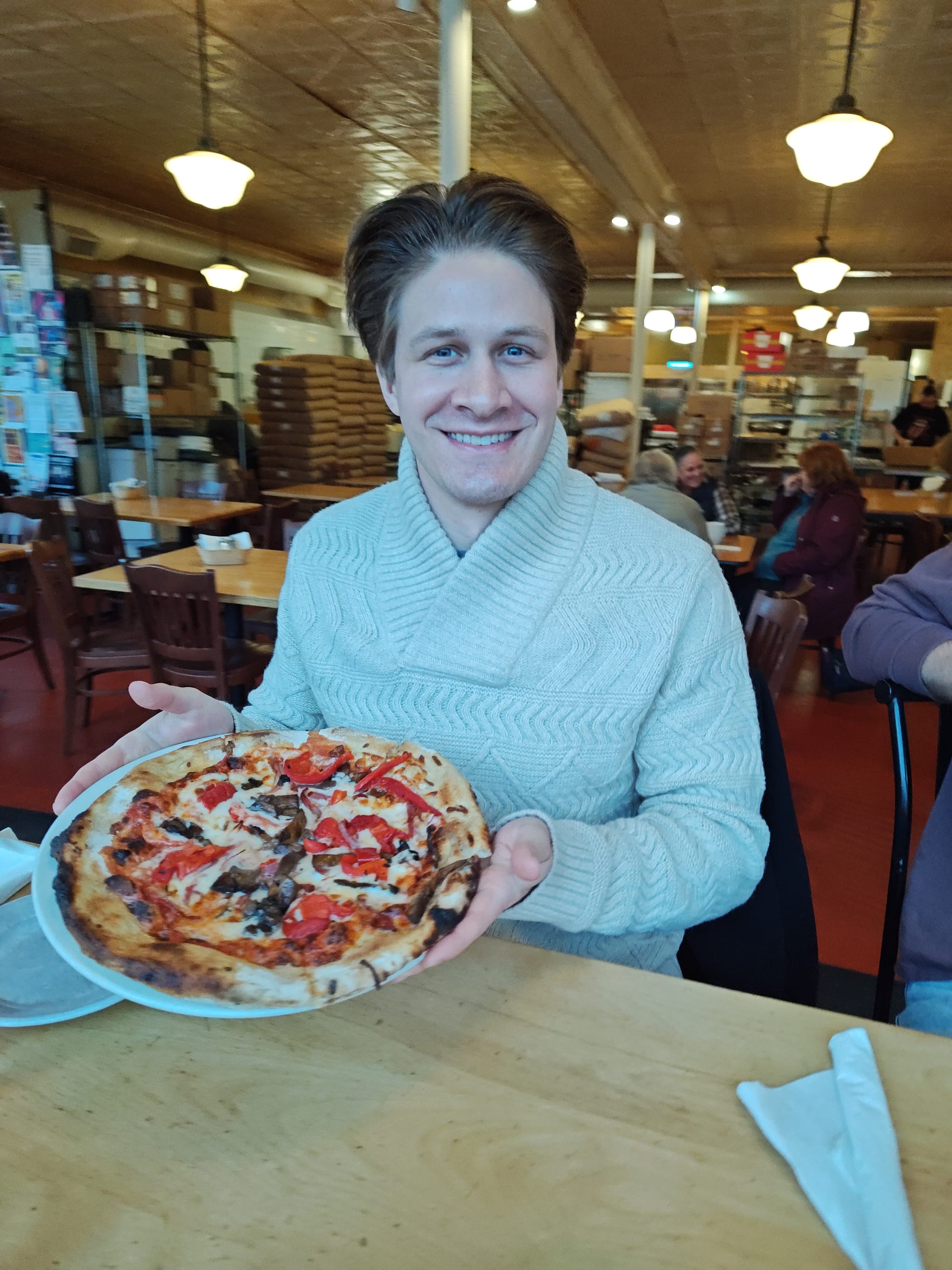 man holding veggie pizza