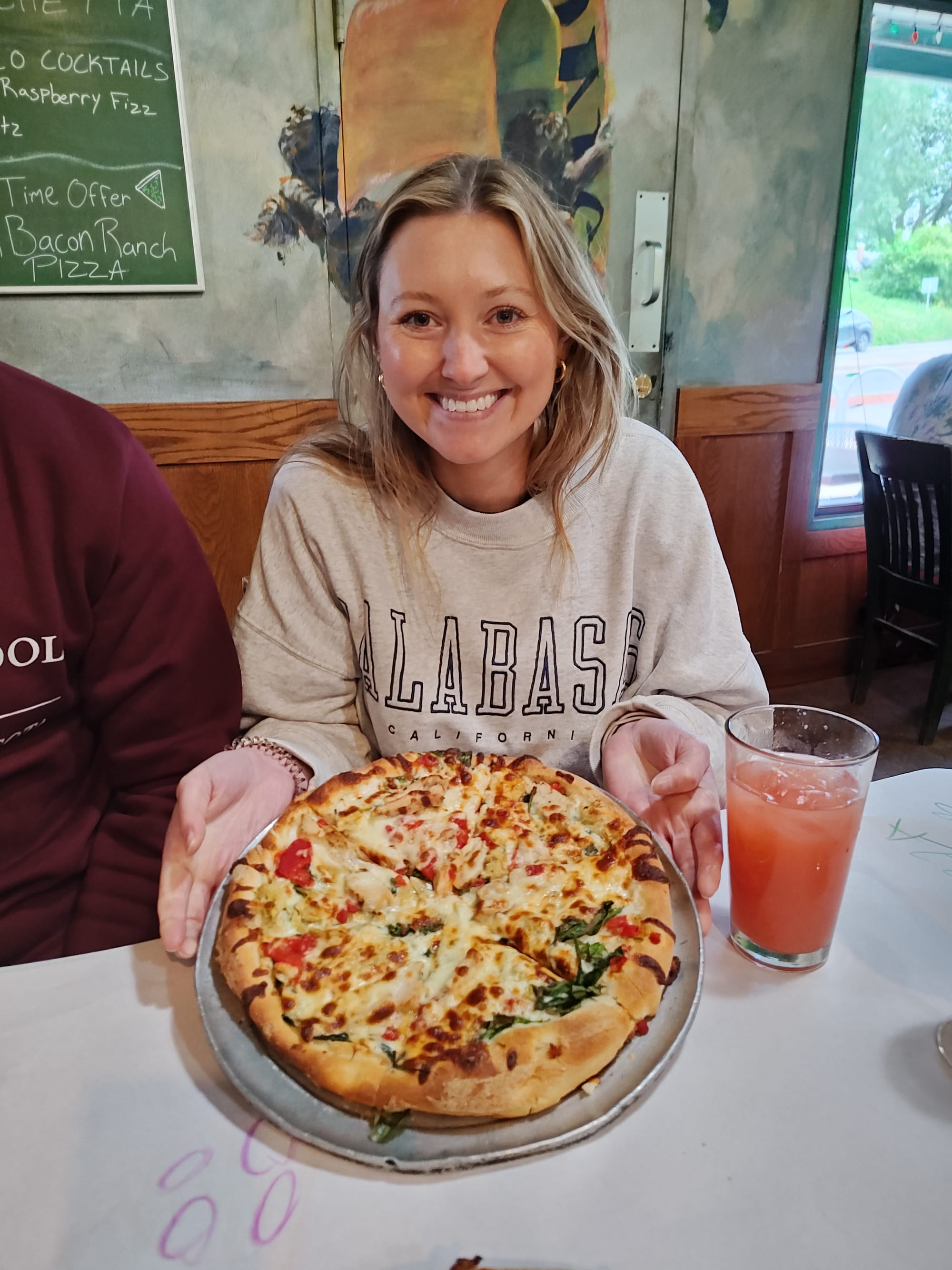 woman holding a white sauce pizza