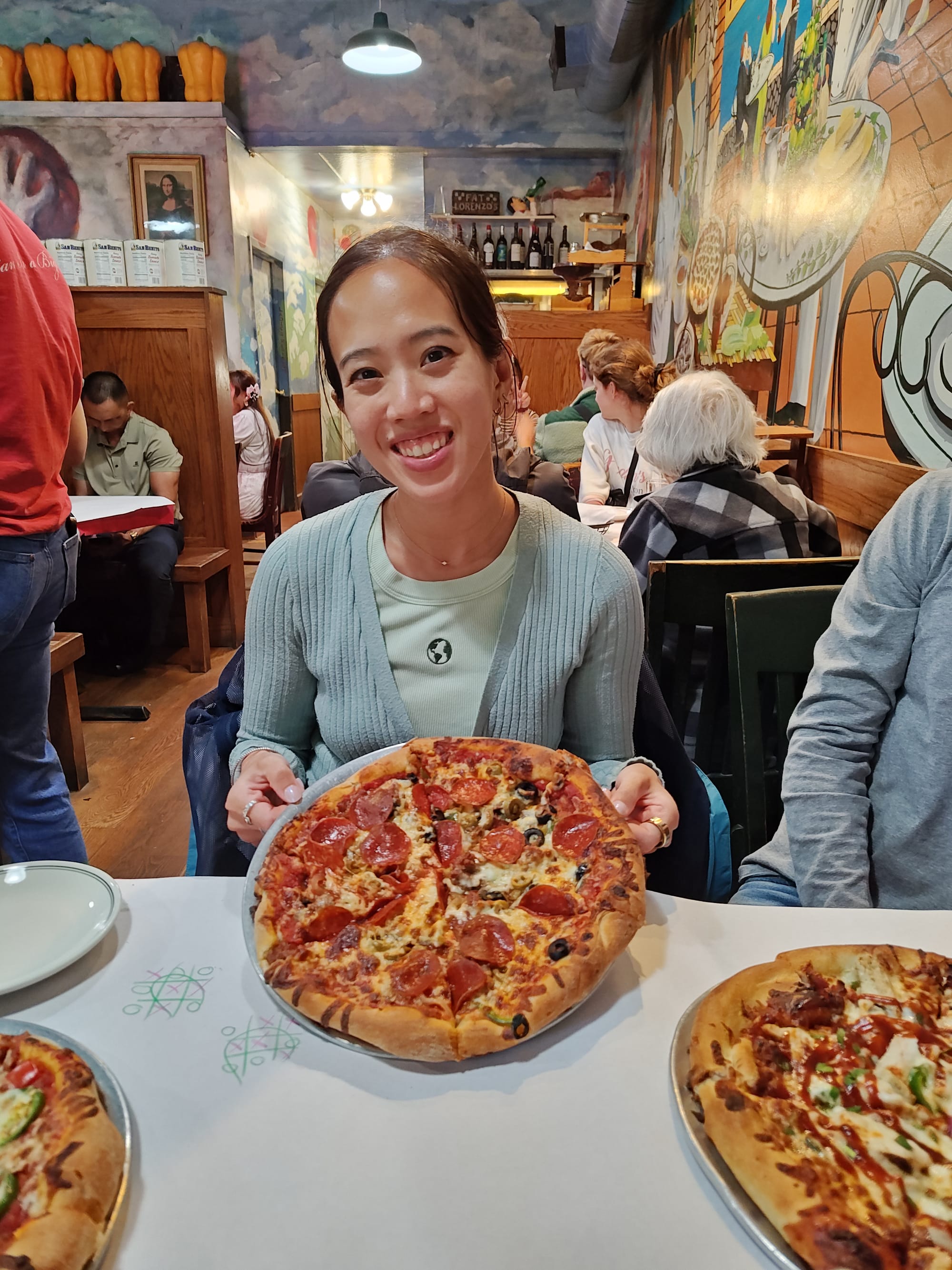 woman holding a combo pizza