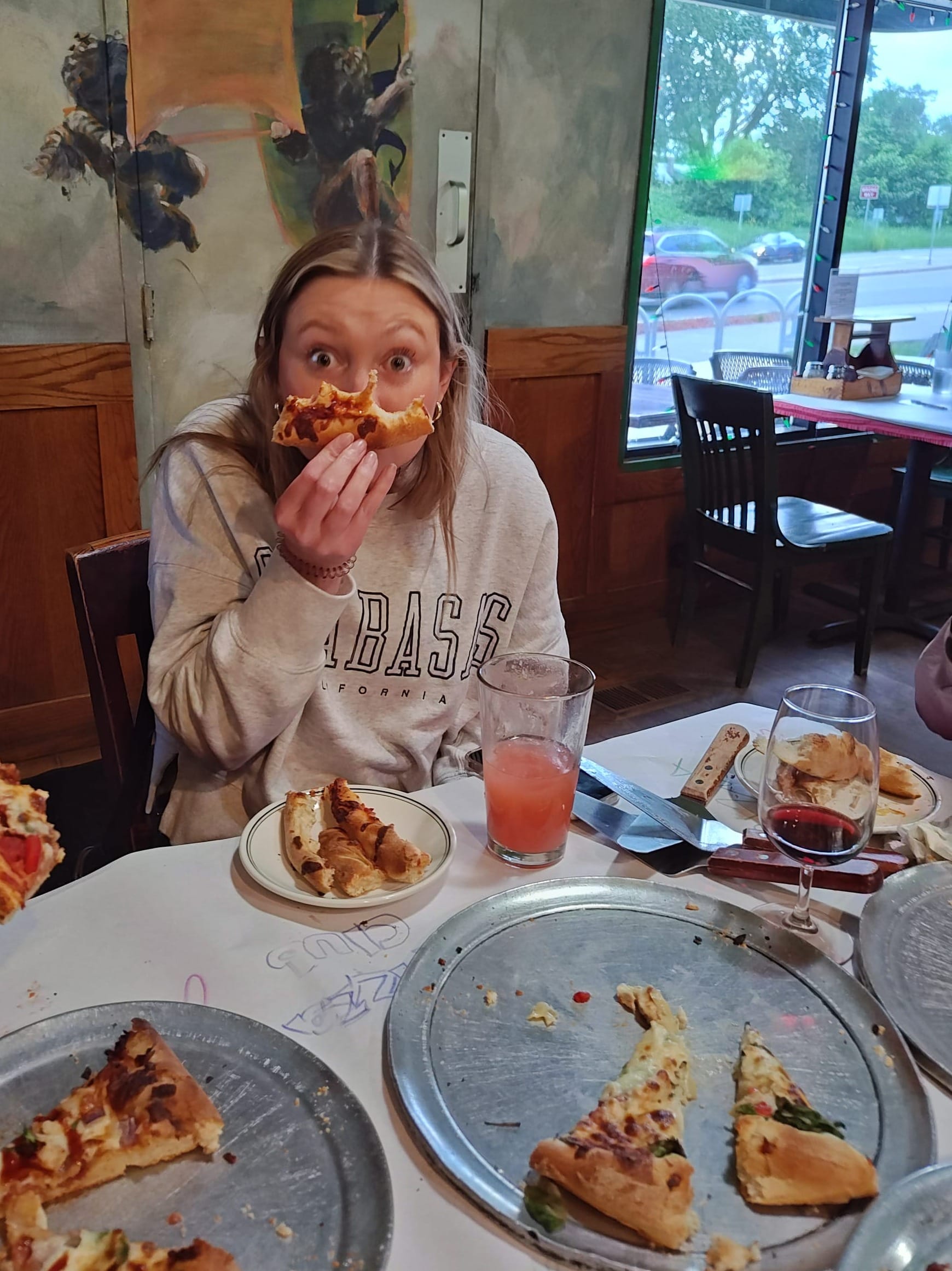 woman holding a thick pizza crust from a slice