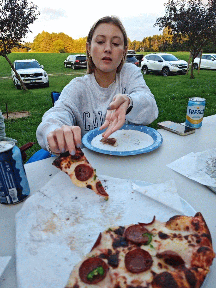woman grabbing a slice of sweet and heat meat pizza