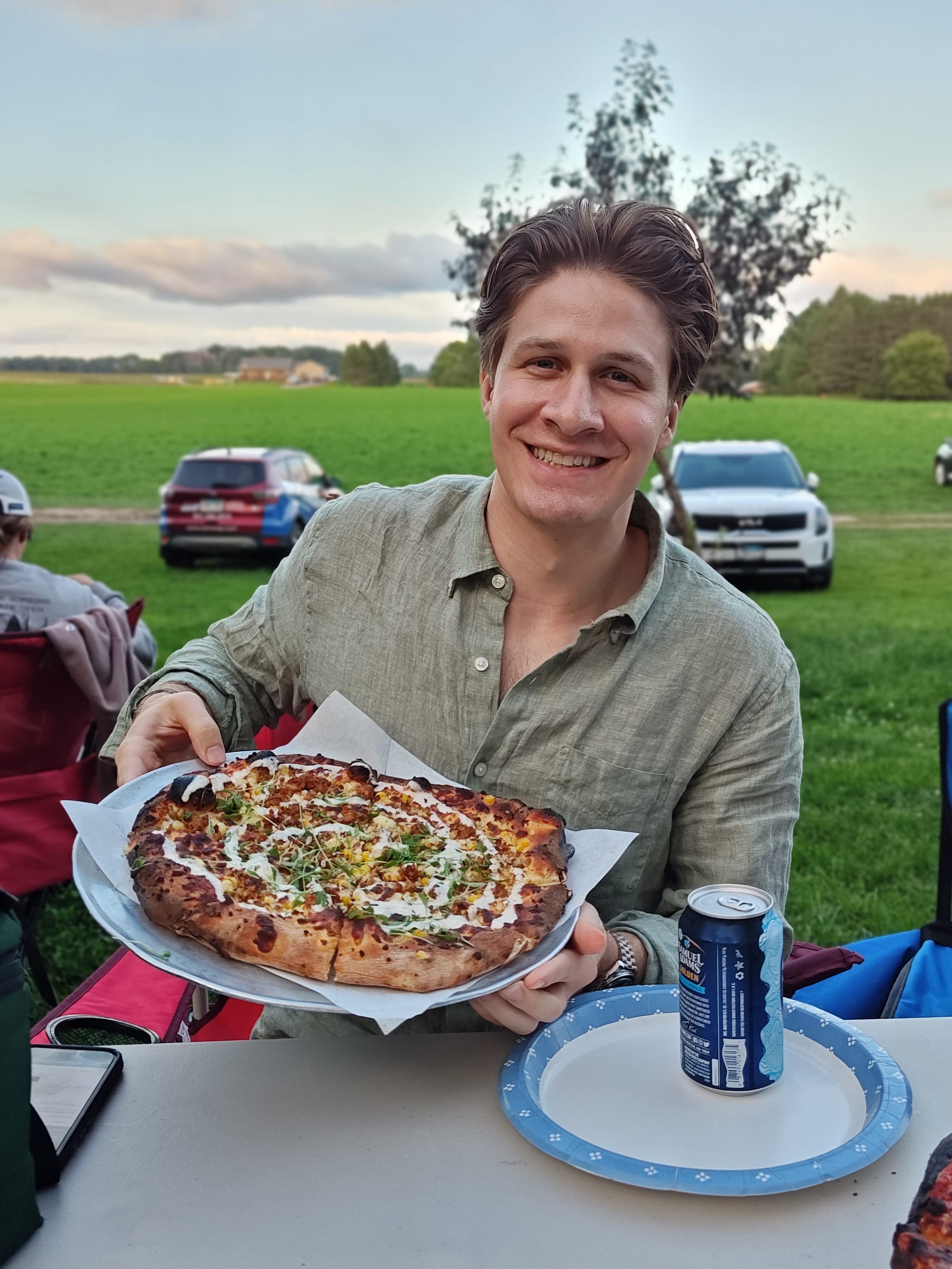 man holding a mexican street corn pizza