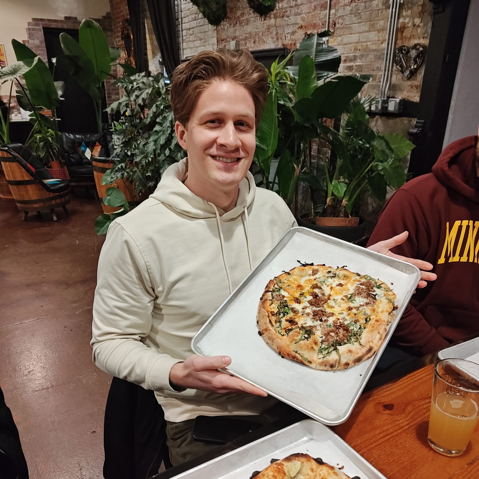 man holding a sausage pizza