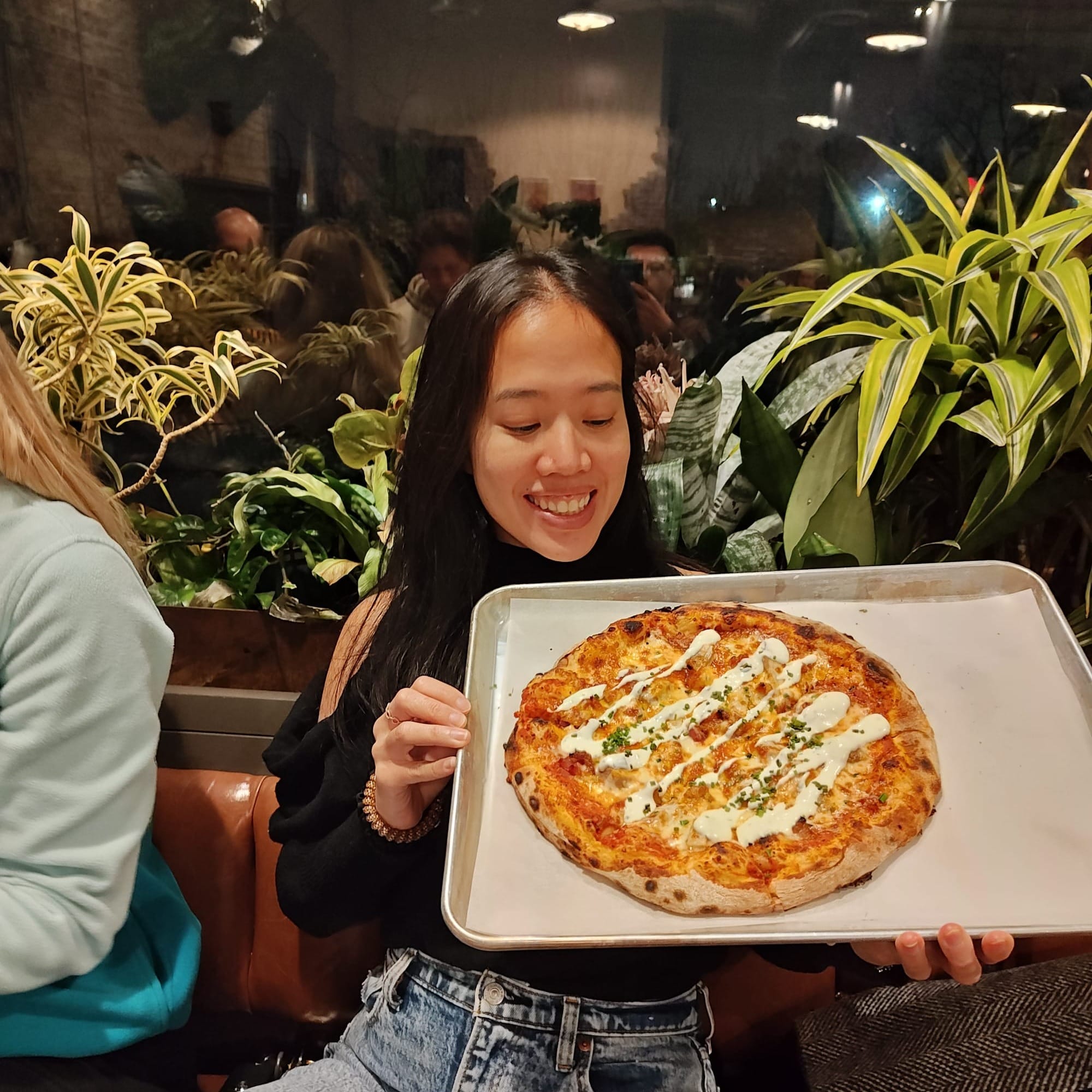 woman holding a chicken bacon ranch pizza
