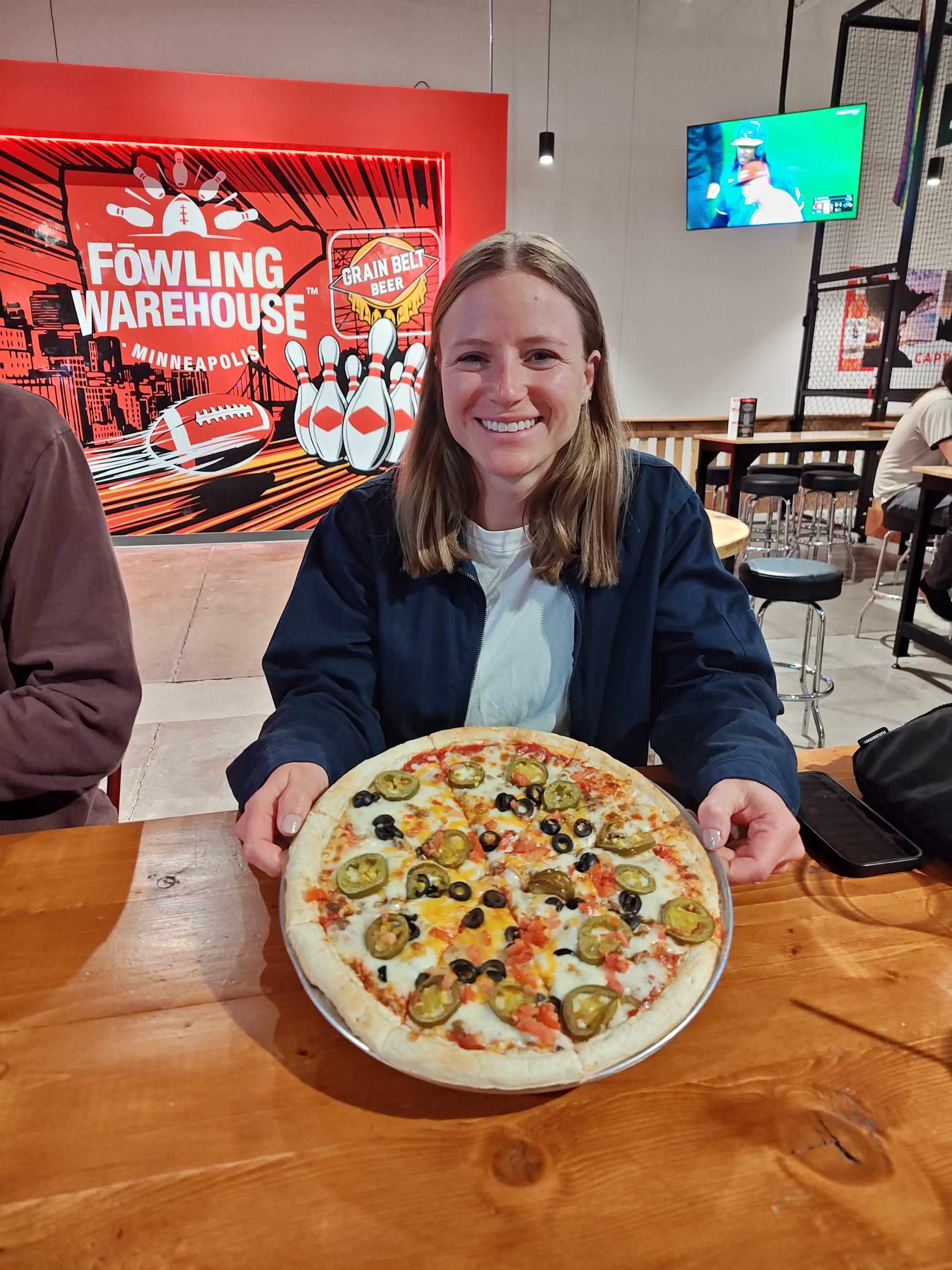 smiling woman holding a taco pizza