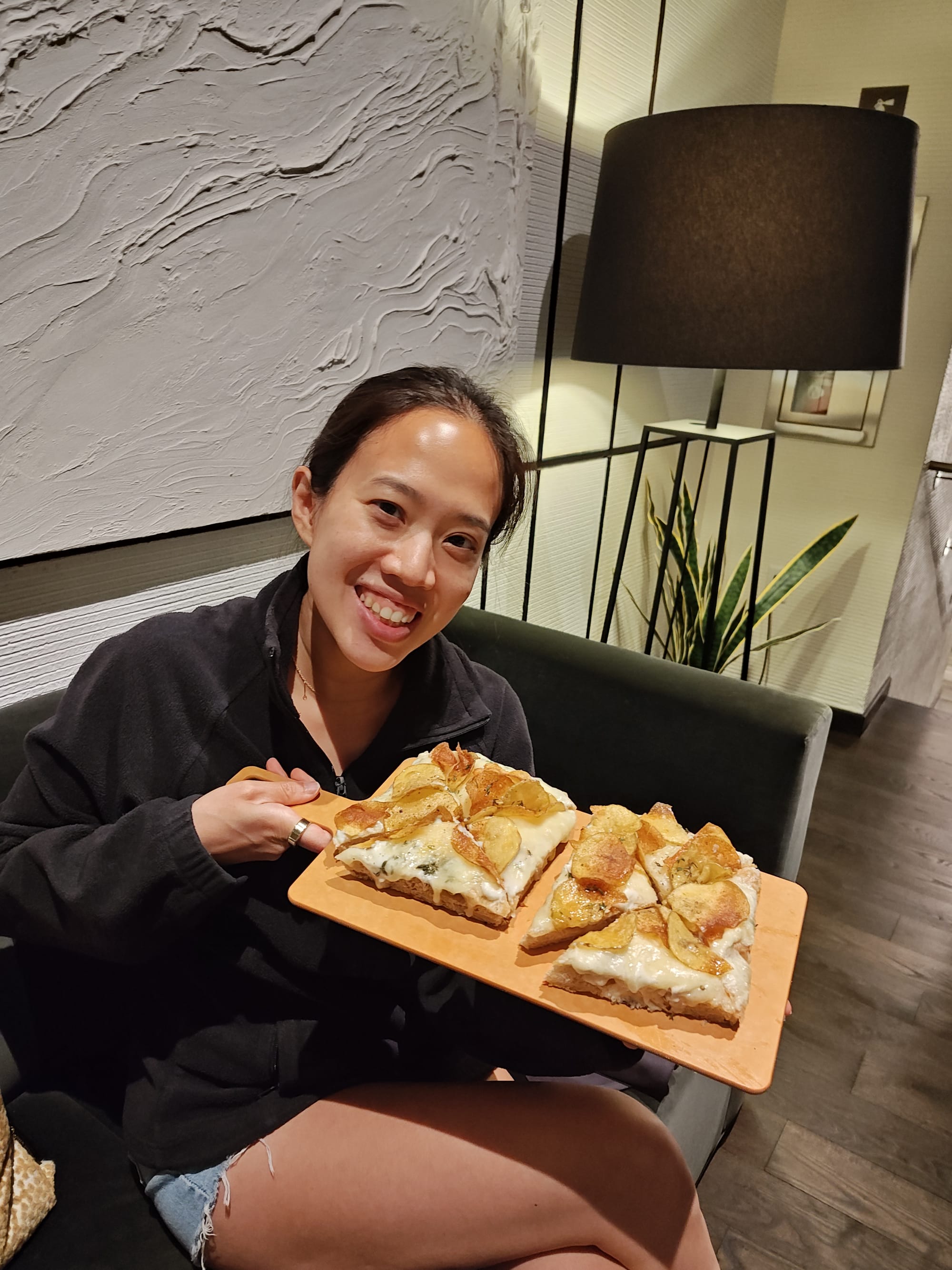 woman holding a potato pizza