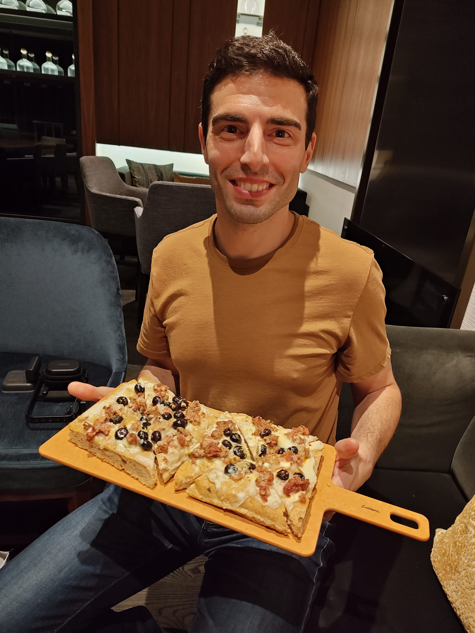 man holding a sausage pizza