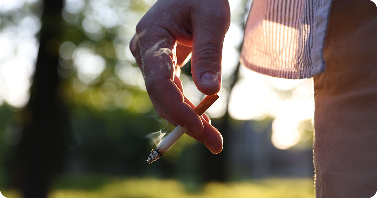 A burning cigarette, highlighting smoking as a major cause of tooth discoloration.