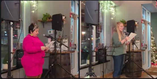 Two women at a microphone flanked by speakers, reading off of a piece of paper.