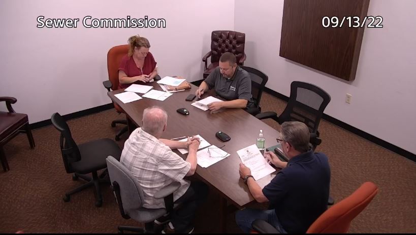 Two members of the Sewer Commission and two members of the Department of Public Works at a table.