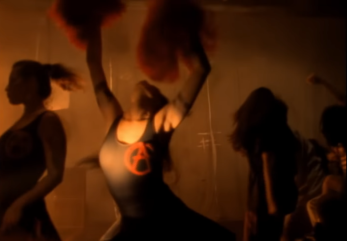 Anarchy cheerleader doing an arms in the air dance of trance like empowerment