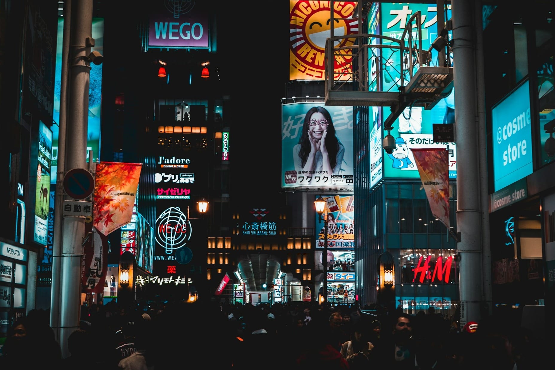 Menschen die nachts auf der Straße gehen umgeben von werbung