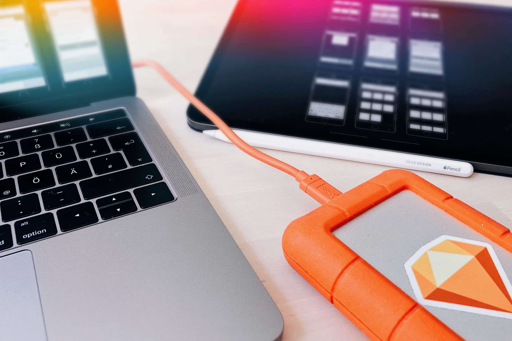 Laptop und Tablet mit externem Speicher, zeigt das digitale Setup und Tools eines UX Designers bei der Arbeit