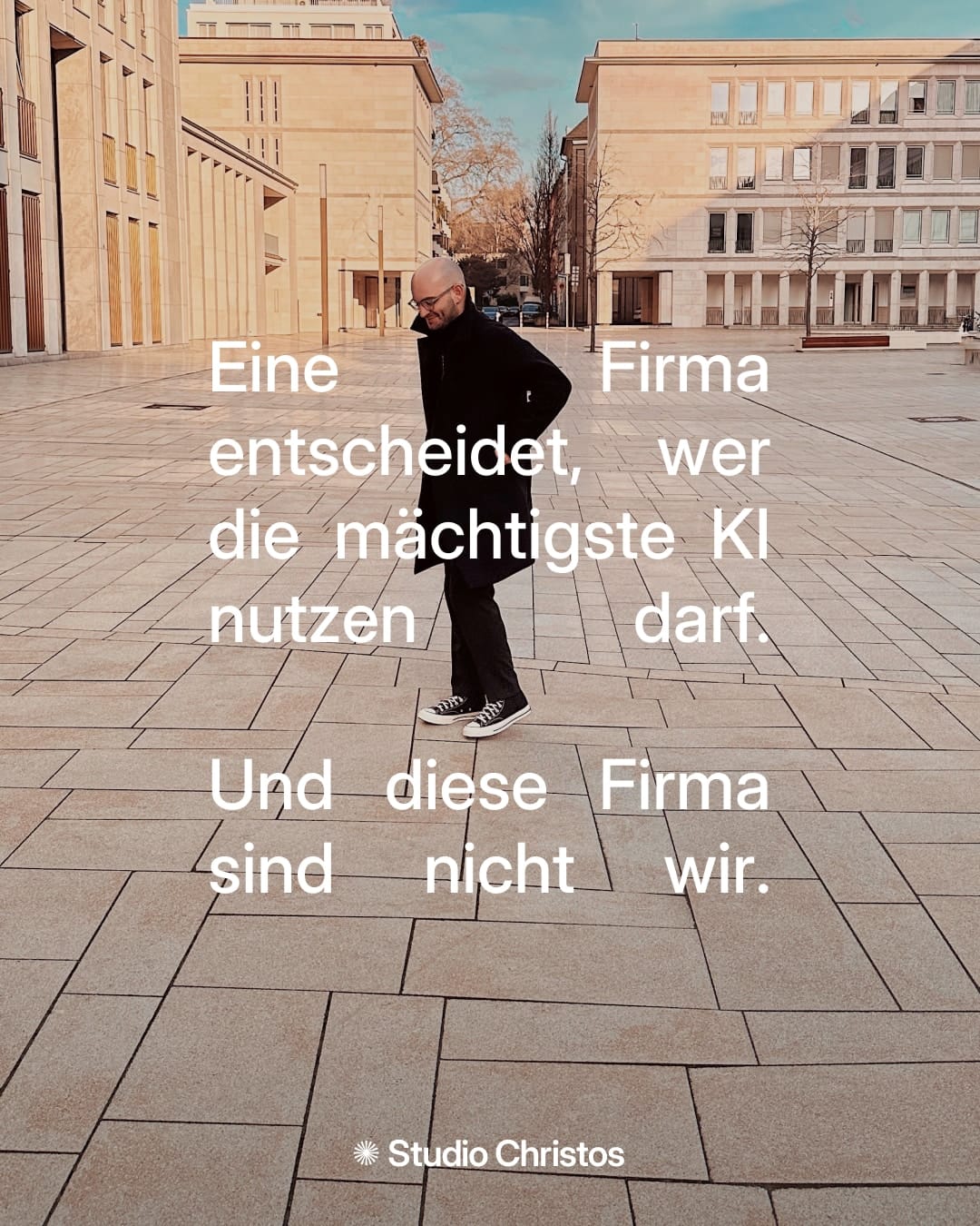 Person auf leerem Platz mit Text: „Eine Firma entscheidet, wer die mächtigste KI nutzen darf. Und diese Firma sind nicht wir.“