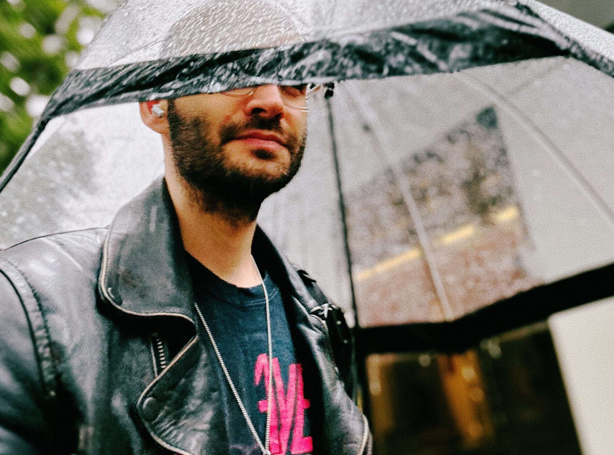 Mann im Regen unter durchsichtigem Schirm, der seine Augen verdeckt, Sinnbild für Misstrauen gegenüber KI in Deutschland