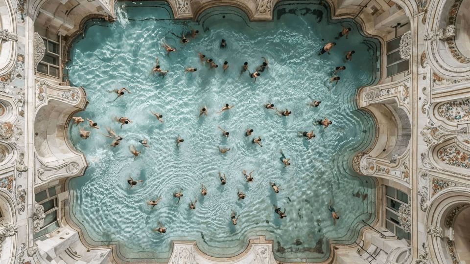 Kunstvoll gestaltetes Schwimmbad mit Menschen umgeben von ornamentalen Wänden