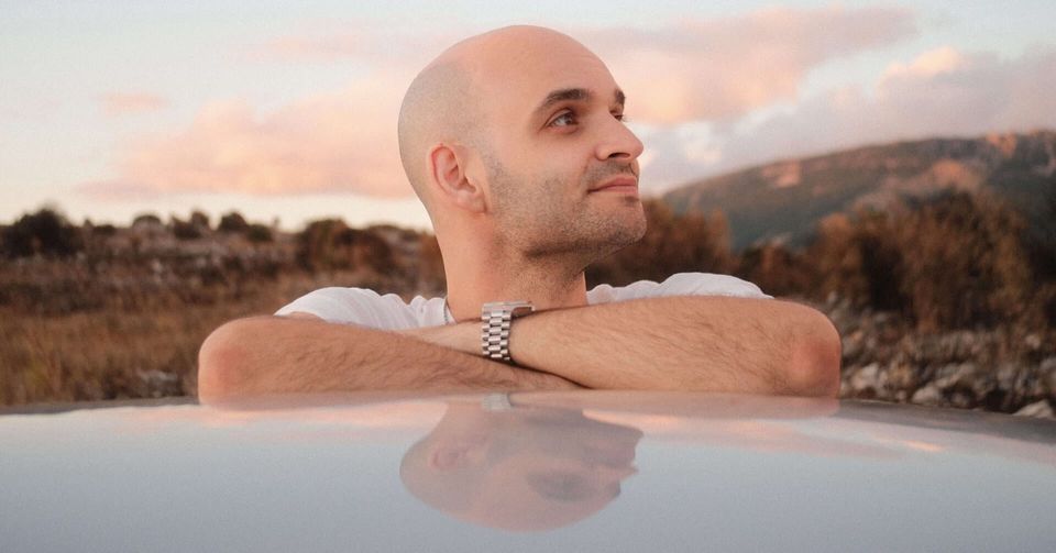 Ein glatzköpfiger Mann blickt ruhig in die Ferne und symbolisiert Selbstbewusstsein, berufliche Klarheit und persönliche Transformation.