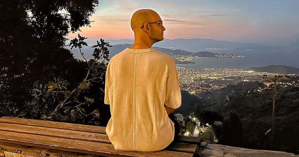 Christos Stavrou sitzt auf Bank mit Blick über Stadtlichter – Symbolbild für Neuanfang und Co-Founder-Suche mit Vision.