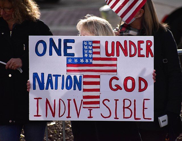A poster reading "One Nation, Under God, Indivisible" from a "Stop the Steal" rally on January 6, 2021