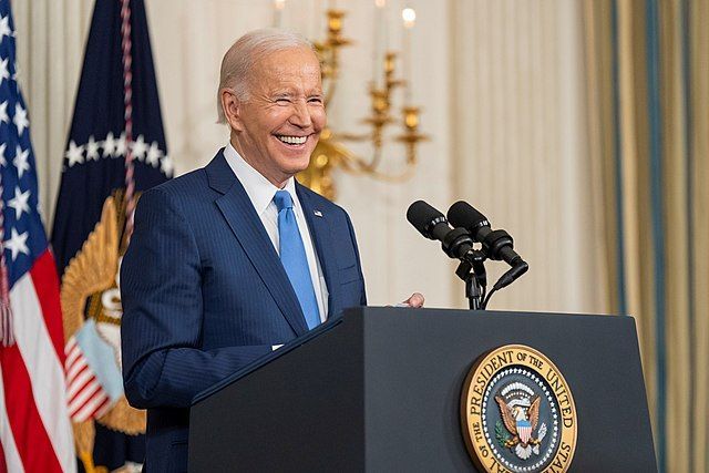 Joe Biden smiling at a podium during a post-midterms press conference