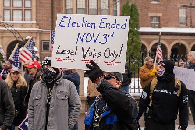 Stop the Steal protester holding a sign that reads "Election Ended Nov 3rd, Legal Votes Only!"