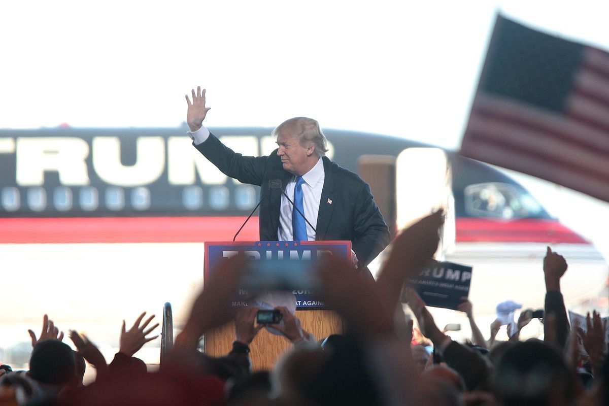 Donald Trump waves to cheering supporters in front of his private jet at a 2015 rally in Mesa, Arizona. 