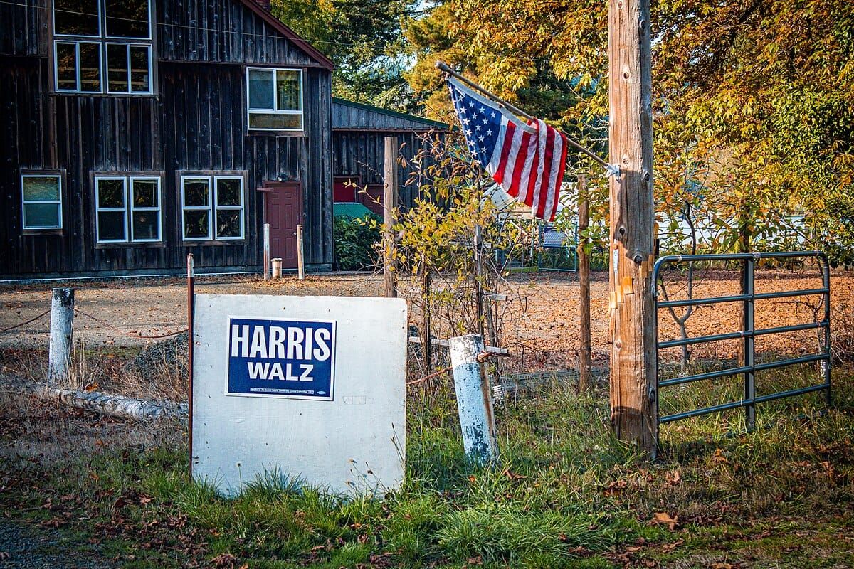 A Harris-Walz sign underneath an American flag outside a home in Blachly, Oregon.