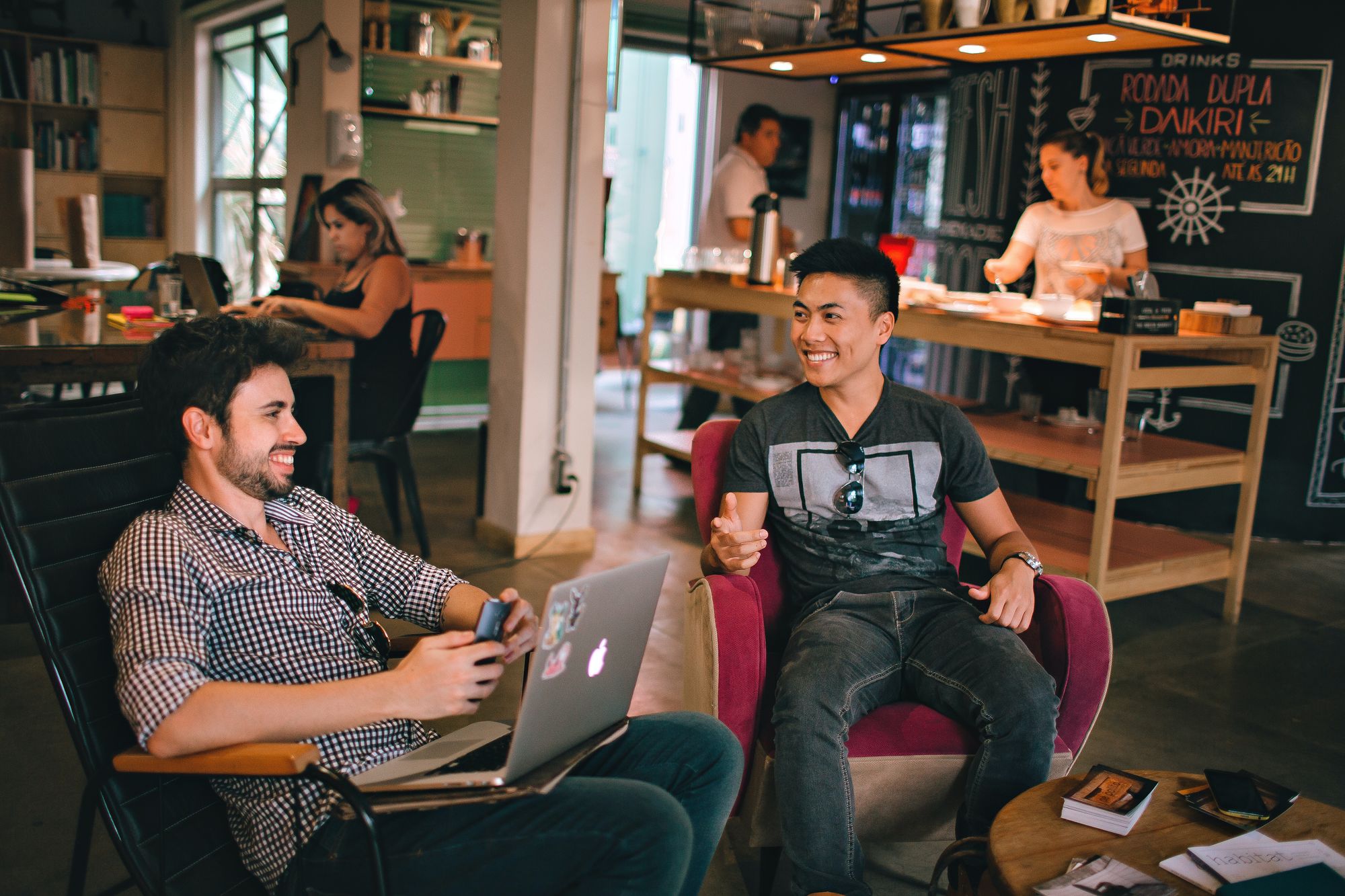 Dos hombres sonrientes mientras parecen estar trabajando en un coworking